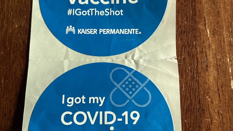 Two blue circular stickers that say "I got my COVID-19 vaccine #igottheshot Kaiser Permanente"