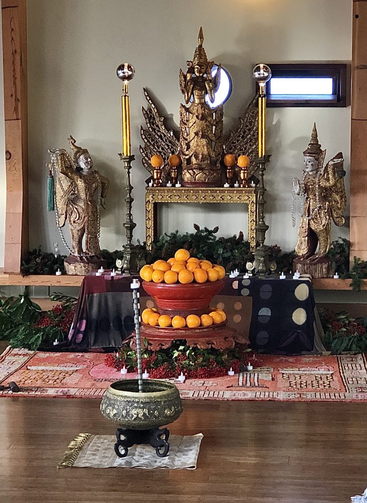 East Asian statues and oranges with an urn.