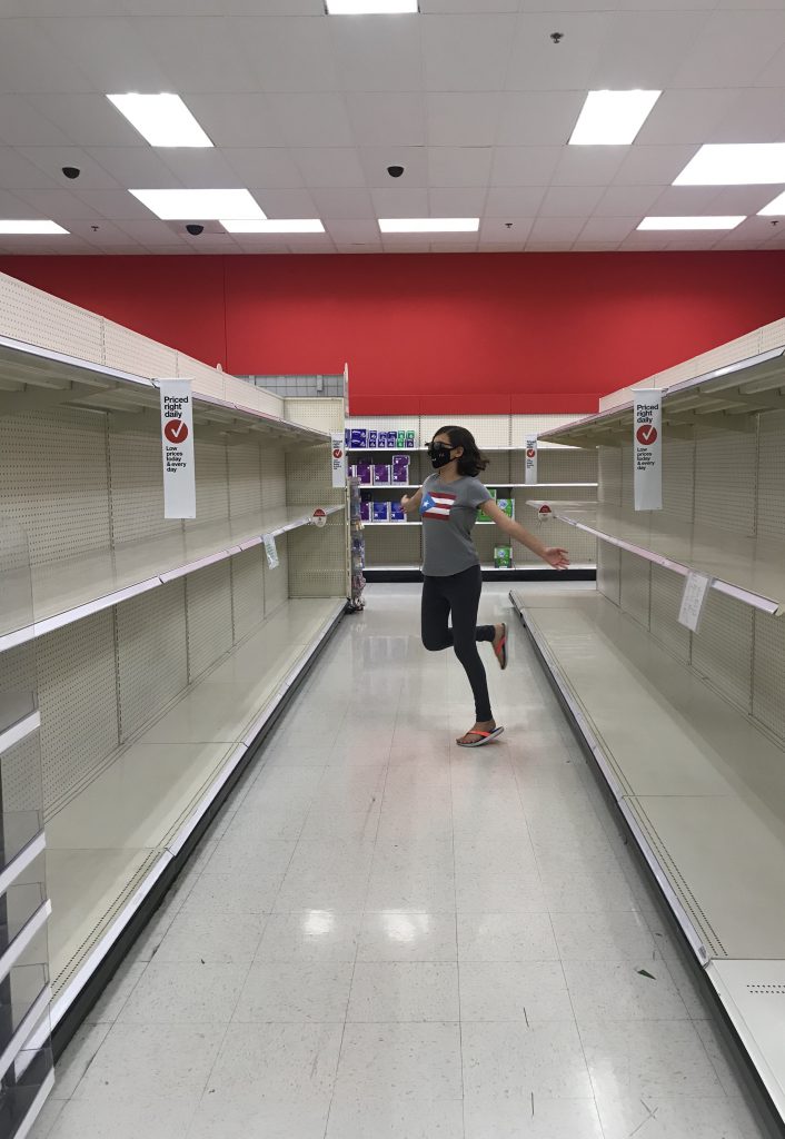 Young women posing in front of empty shelves at Target.