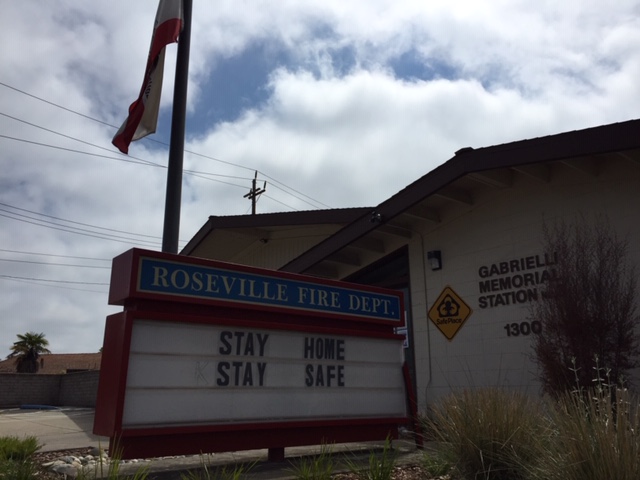 The tan exterior of a fire station beneath a blue sky.